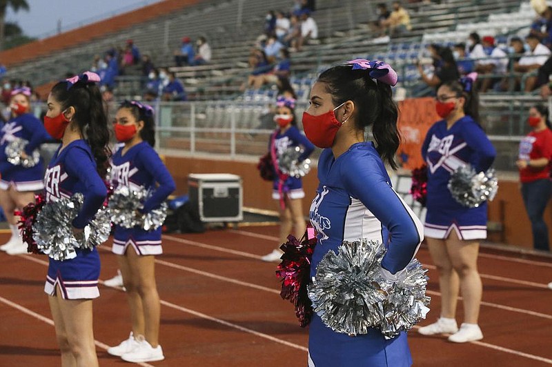 Cheerleaders from Porter Early College High School wear masks while cheering Thursday during a high school football game in Brownsville, Texas. More photos at arkansasonline.com/1024pandemic/.
(AP/The Brownsville Herald/Denise Cathey)
