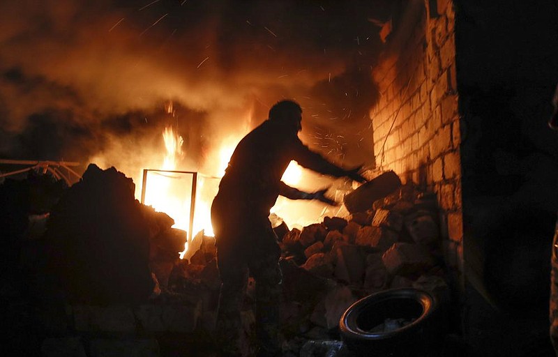 People try to remove tires from a car shop that was set on fire in the separatist region of Nagorno-Karabakh as Azerbaijan and Armenia exchanged fire Friday.
(AP)