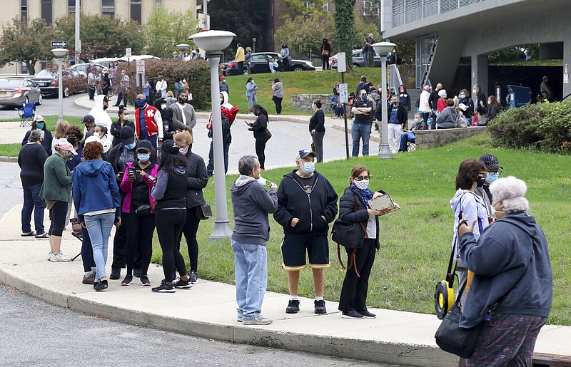 Voters line up in front of the Yonkers (N.Y.) Public Library on Saturday, Oct. 24, 2020, New York's first day of early voting in the presidential election.