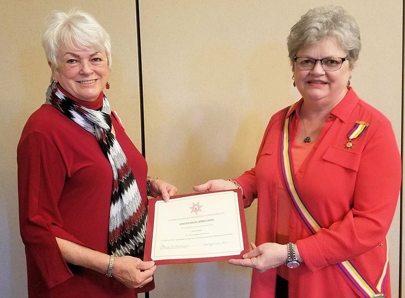 Sheila Beatty-Krout receives a certificate from Sharon Stanley Wyatt, Pine Bluff resident and governor of the Continental Society Daughters of Indian Wars at Arkansas. The national society honored Beatty-Krout, who designed the Native American Ancestor Membership Certificate.