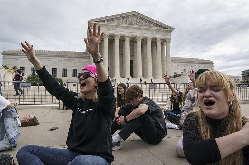 Evangelical Christians pray Saturday outside the Supreme Court in Washington as Republicans in the Senate work in a rare weekend session to advance the confirmation of Judge Amy Coney Barrett for the high court. More photos at arkansasonline.com/1025barrett/
(AP/J. Scott Applewhite)