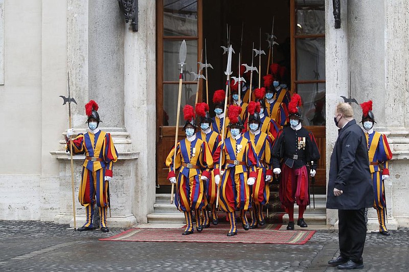 Masked Swiss Guard members march out of the St. Damaso courtyard Saturday at the Vatican after Spanish Prime Minister Pedro Sanchez visited with Pope Francis. More photos at arkansasonline.com/1025sanchez/
(AP/Alessandra Tarantino)