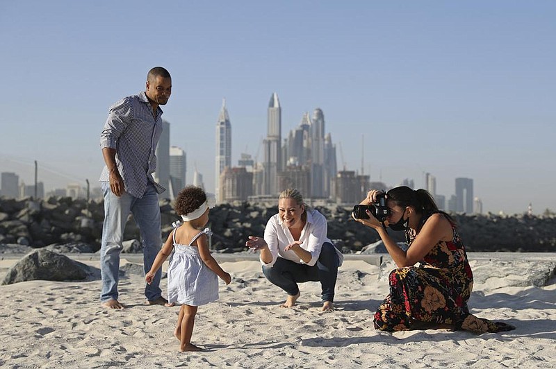 Freelance lifestyle photographer Paula Hainey takes photos of Darrin Chapman, a pilot recently laid off by long-haul carrier Emirates, his wife, Jodi Chapman, and their daughter Harper, in Dubai, United Arab Emirates, in mid-October. 
(AP/Kamran Jebreili) 