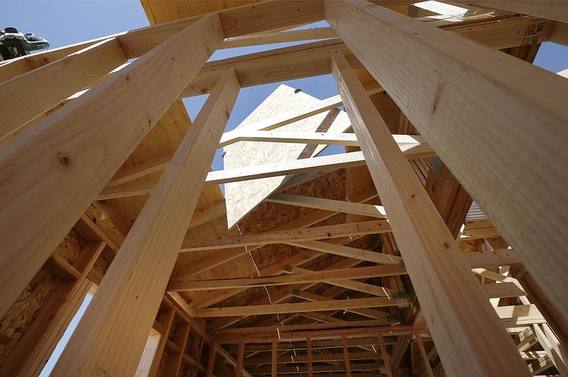 A contractor works with plywood while framing the roof of a home under construction earlier this year in Park City, Utah. (Bloomberg News/George Frey) 
