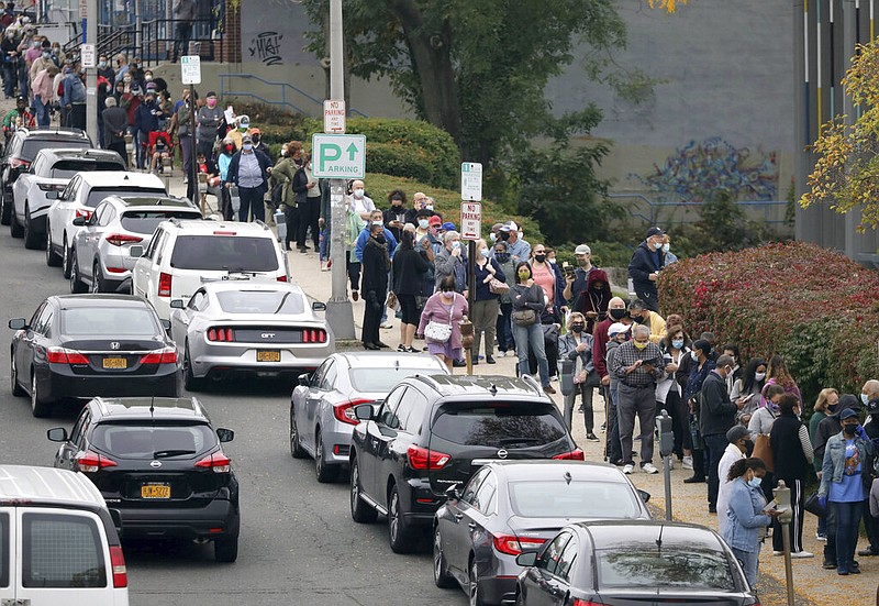 Voters line up in front of the Yonkers Public Library in Yonkers, N.Y., on Saturday, Oct. 24, 2020 as the first day of early voting in the presidential election begins across New York state.