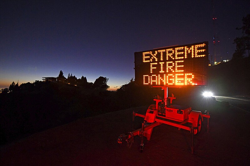 A roadside sign warns motorists of extreme fire danger on Grizzly Peak Boulevard, in Oakland, Calif., Sunday, Oct. 25, 2020.
