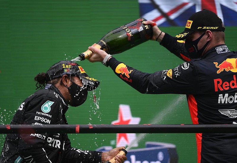 Formula One driver Lewis Hamilton (left) is doused with champagne by Mercedes teammate Valtteri Bottas after Hamilton won Sunday’s Portuguese Grand Prix. It was Hamilton’s record-breaking 92nd career F1 victory. (AP/Rudy Carezzevoli) 