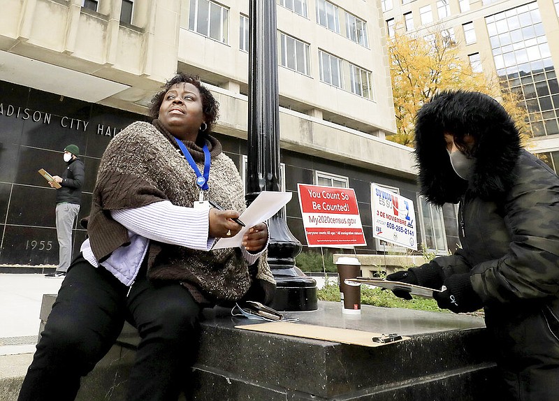 FILE - In this Oct. 20, 2020, file photo, Theola Carter, left, and Carrie Braxton fill out their ballots on the first day of the state's in-person absentee voting window for the Nov. 3 election outside the City-County Building In Madison, Wis. With just a week to go until Election Day and 320,000 outstanding absentee ballots in hotly contested battleground Wisconsin, the push is on to get all ballots returned after the U.S. Supreme Court declined to extend the counting deadline. (John Hart/Wisconsin State Journal via AP File)