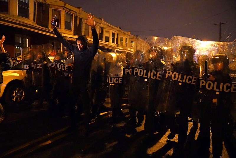 Sharif Proctor lifts his hands up in front of the police line during a protest in response to the police shooting of Walter Wallace Jr., Monday, Oct. 26, 2020, in Philadelphia.