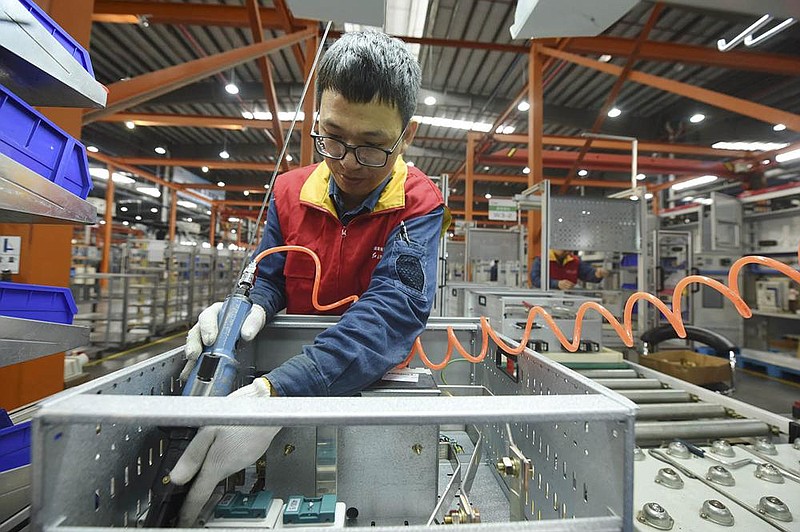 A worker installs a power-distribution cabinet last week in a subsidiary of the State Grid Corp. in Hangzhou, China. The ruling Communist Party wants to increase Chinese industry’s reliance on domestic suppliers and consumers. (AP)
