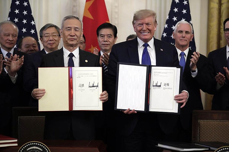 FILE - In this Jan. 15, 2020, file photo President Donald Trump holds a trade agreement with Chinese Vice Premier Liu He, in the East Room of the White House in Washington. Trump spent four years upending seven decades of American trade policy. He started a trade war with China, slammed America‚Äôs closest allies by taxing their steel and aluminum and terrified Big Business by threatening to take a wrecking ball to $1.4 trillion in annual trade with Mexico and Canada.
 Trump‚Äôs legacy on trade is likely to linger, regardless whether Joe Biden replaces him in the White House in January 2021.(AP Photo/Evan Vucci)