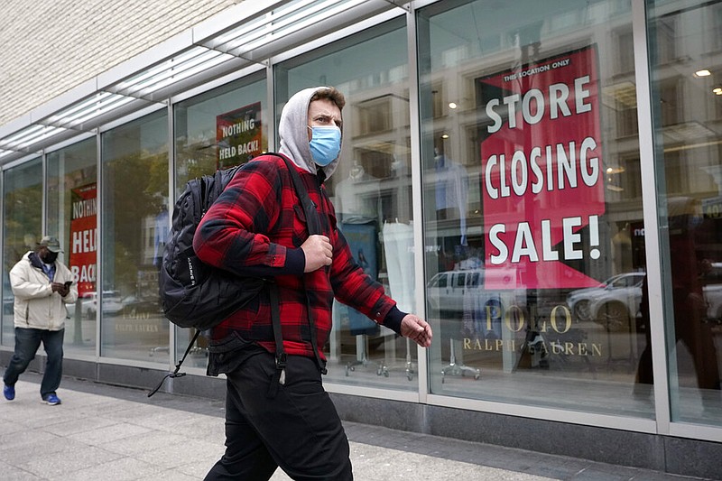 A passerby walks past a store closing sign in the window of a Boston department store on Tuesday, Oct. 27, 2020. The epic economic collapse in the spring was followed by a record rebound over the summer, though analysts warned Thursday, Oct. 29, that the surge was powered by federal aid that has since dried up.