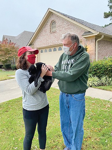 Maureen Martin of Little Rock takes her cat Snow Monstah from Tom DeBlack of Conway. On Tuesday, DeBlack found the cat, who was wearing a collar. It’s a mystery as to how the cat traveled 37 miles from Martin’s home to DeBlack’s home. DeBlack lost a black cat he was fostering, and it also was found by a neighbor on Tuesday — National Black Cat Day.