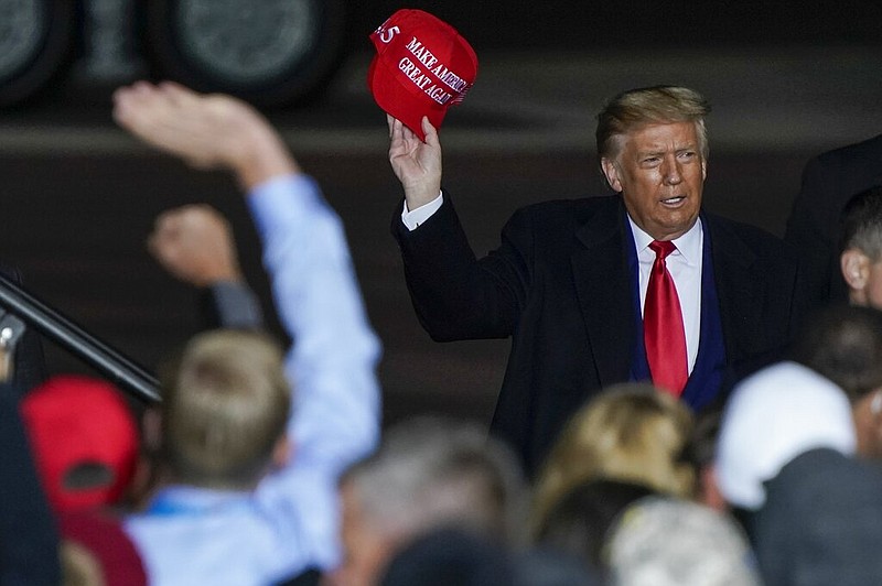 FILE - In this Sept. 17, 2020 file photo President Donald Trump throws a hat to the crowd after speaking at a campaign rally at the Central Wisconsin Airport in Mosinee, Wis.