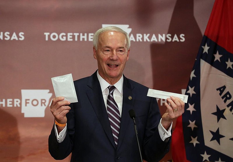 Gov. Asa Hutchinson shows off one of the Abbott BinaxNOW Rapid Test kits during a press conference on Wednesday, Oct. 14, 2020, at the State Capitol in Little Rock. 
(Arkansas Democrat-Gazette/Thomas Metthe)