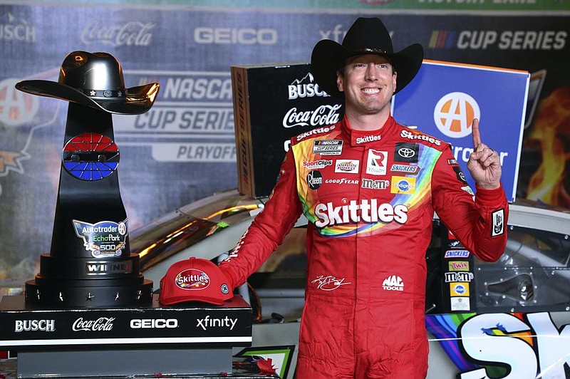 Kyle Busch poses with the trophy in Victory Lane after winning the NASCAR Cup Series auto race at Texas Motor Speedway in Fort Worth, Texas, Wednesday, Oct. 28, 2020. (AP Photo/Richard W. Rodriguez)