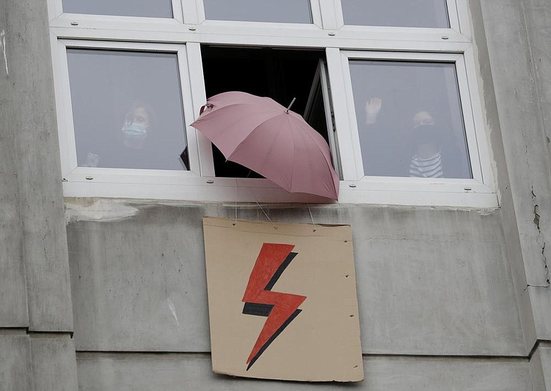 From their windows Wednesday, people use umbrellas to signal support for a protest for women’s rights in Warsaw, Poland.
(AP/Czarek Sokolowski)