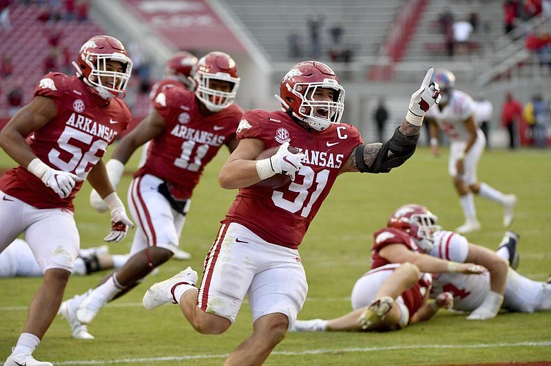 Arkansas linebacker Grant Morgan celebrates as he returns an interception for a touchdown Oct. 17 against Ole Miss. Morgan, who leads the nation averaging 13 tackles per game, has found his road to success full of peaks and valleys.
(AP/Michael Woods)