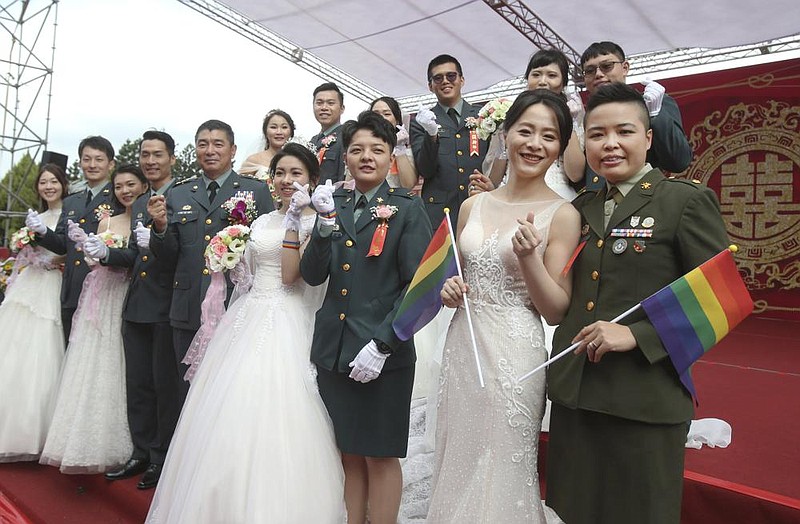 Two lesbian couples (center, from left) Chen Ying-hsuan and Li Li-chen and Wang Yi and Yumi Meng take part in a military mass wedding Friday in Taoyuan, Taiwan. More photos at arkansasonline.com/1031taoyuan/.
(AP/Chiang Ying-ying)