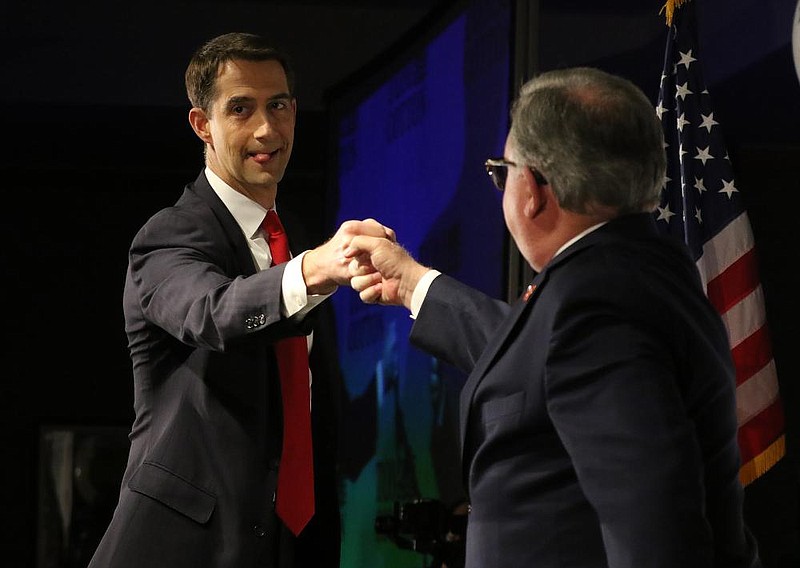 U.S. Sen. Tom Cotton (left) gets a fist pound from Arkansas Republican Party chairman Doyle Webb as he takes the stage for his victory speech on Tuesday, Nov. 3, 2020, during the Arkansas Republican Party election event at the Embassy Suites Hotel in Little Rock. 
(Arkansas Democrat-Gazette/Thomas Metthe)