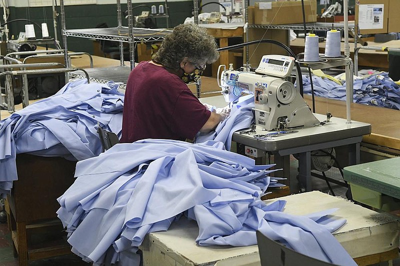 Marlene Long of Shamokin, Pa., sews a U.S. Postal Service shirt last month during the official opening of Brigade Manufacturing North LLC in Ashland, Pa. The Institute for Supply Management reported Monday that its manufacturing index rose by 3.9 percent- age points in October. (Republican-Herald/Jacqueline Dormer) 