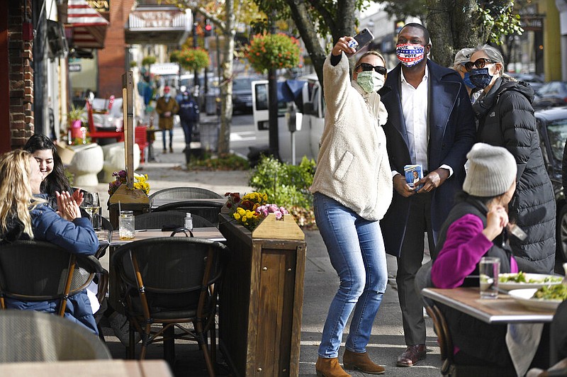 FILE - In this Tuesday, Nov. 3, 2020 file photo, Democratic candidate Mondaire Jones poses for a selfie while campaigning for the U.S. House of Representatives 17th Congressional seat on Election Day in Tarrytown, N.Y. With the addition of Jones and Ritchie Torres winning in the 2020 election, there will be nine openly LGBTQ members of the House as of January 2021, The seven incumbents all won their races. (AP Photo/Jessica Hill)

