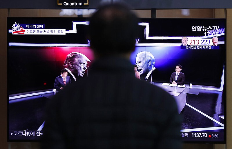 A man watches a TV screen showing the images of U.S. President Donald Trump and Democratic presidential candidate former Vice President Joe Biden during a news program of the U.S. presidential election, at the Seoul Railway Station in Seoul, South Korea, Wednesday, Nov. 4, 2020.