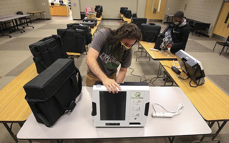 In this file photo Pulaski County election official Derrick Cagle packs voting machines into cases Wednesday at the William F. Laman Public Library in North Little Rock as election officials collect voting machines and equipment from polling sites.
(Arkansas Democrat-Gazette/Staton Breidenthal)