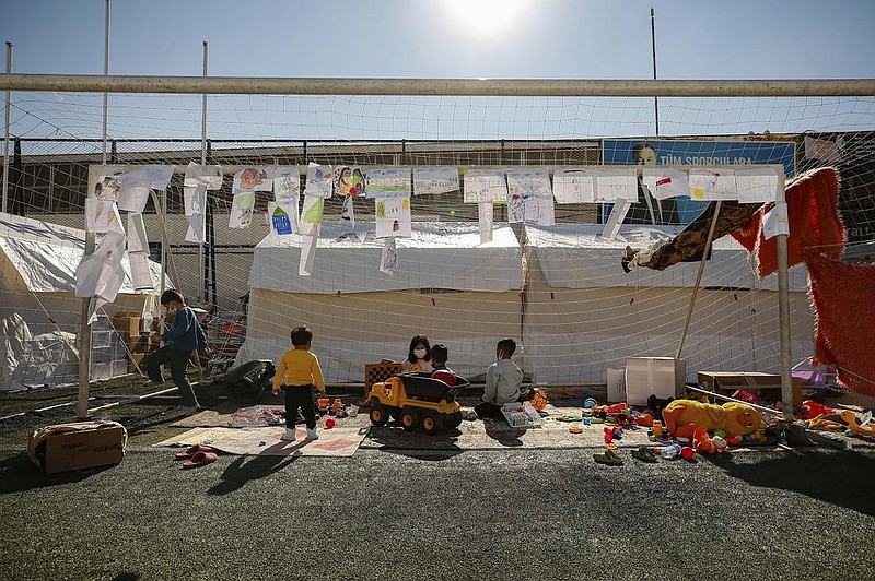 Children pass the time Wednesday near tents set up at a soccer stadium for residents who remain homeless after the Oct. 30 earthquake in Izmir, Turkey.
(AP/Emrah Gurel)
