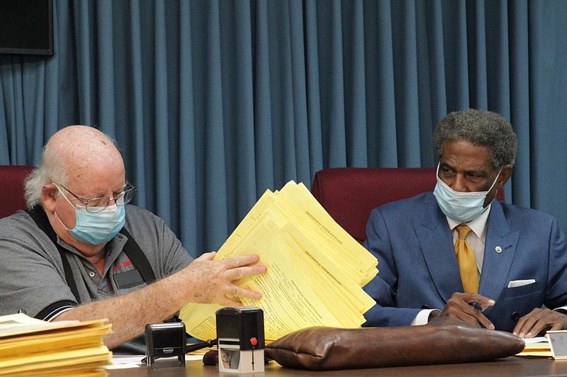 Jefferson County election commissioners Michael Adam (left) and Ted Davis examine and sign envelopes containing provisional ballots that are being adjudicated. Officials said 128 provisional ballots cast during early voting were rejected either for lack of proper identification or because the voters who cast them could not be verified as being registered to vote in Jefferson County. Of provisional ballots cast on Election Day, 89 were rejected because the voter registration could not be verified.
(Pine Bluff Commercial/Dale Ellis)