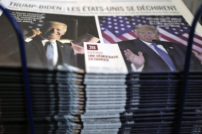 A stack of Le Monde newspapers sits at a newsstand Wednesday in Paris. The headline proclaims in French: “Trump-Biden: the United States is tearing itself apart.”
(AP/Francois Mori)