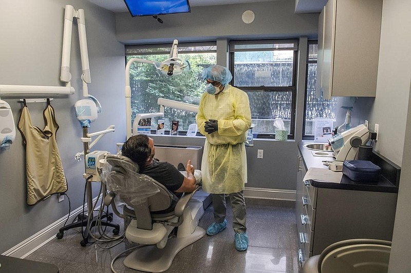 A dentist counsels a patient in late June in New York City’s Manhattan. Dentists and other health care providers have had to increase spending on personal protective gear. Some have sought to pass the costs on to patients.
(The New York Times/Brittainy Newman)