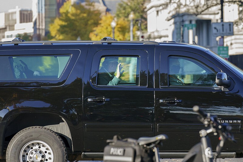 President Donald Trump waves to supporters as his motorcade arrives at the White House in Washington on Sunday, Nov. 8, 2020, upon his return from golfing at his Trump National Golf Club in Sterling, Va.