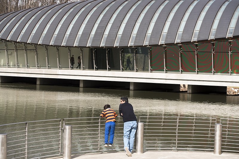 Chakra Dusetti of Bentonville looks out onto the water with his son at Crystal Bridges in Bentonville in this 2018 file photo.