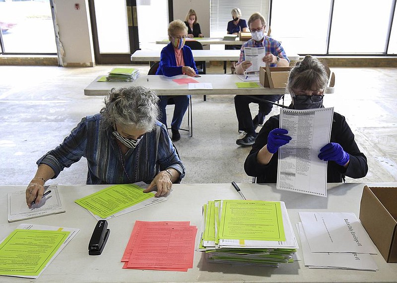 Officials work at the Pulaski County Election Commission in Little Rock to tabulate provisional ballots cast during the Nov. 3 election in this Nov. 11, 2020 file photo.