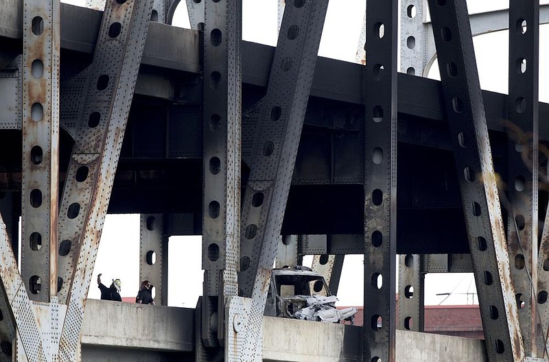 Police and fire personnel work Wednesday at the scene of a traffic accident and re on the Brent Spence Bridge in Coving- ton, Ky. (AP/The Cincinnati Enquirer/Albert Cesare) 