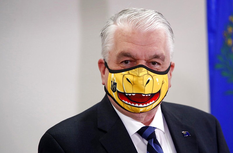 Nevada Gov. Steve Sisolak speaks during a news conference at the Grant Sawyer State Building in Las Vegas in this Sept. 29, 2020, file photo. Sisolak's face mask is themed after the Vegas Golden Knights' mascot, Chance the Golden Gila Monster.