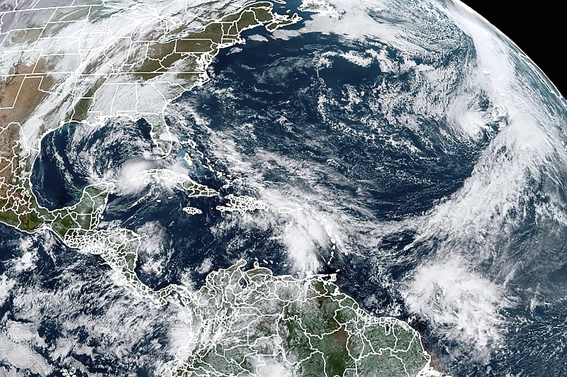 This satellite image, taken at 9:40 a.m. CST on Tuesday, Nov. 10, 2020, and made available by the National Oceanic and Atmospheric Administration, shows Tropical Storm Eta in the Gulf of Mexico; then-Subtropical Storm Theta at right; and a tropical wave to the south that became Tropical Storm Iota on Friday, Nov. 13, 2020.