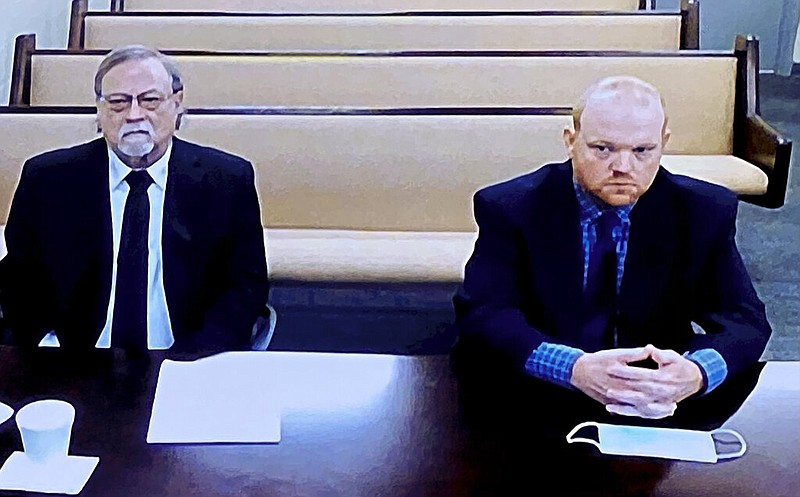 In this image made from video, Gregory (left) and Travis McMichael, the father and son accused in the February 2020 shooting death of Ahmaud Arbery in Georgia, listen via closed-circuit television in the Glynn County (Ga.) detention center on Thursday, Nov. 12, 2020. Lawyers were arguing for bond to be set.