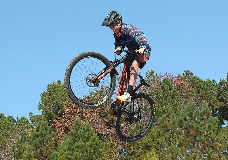 Marshall Davis, 13, of Bentonville, goes over a jump at Cederglades Park Friday, Nov. 13, 2020. Davis attended the second Gudrun mountain bike festival with his family. - Photo by Richard Rasmussen of The Sentinel-Record