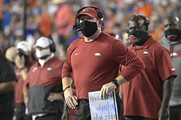 Arkansas defensive coordinator Barry Odom, center, watches a stadium video monitor after Florida scored a touchdown during the first half of an NCAA college football game, Saturday, Nov. 14, 2020, in Gainesville, Fla. Odom was acting as the Razorbacks' interim head coach during the game. (AP Photo/Phelan M. Ebenhack)