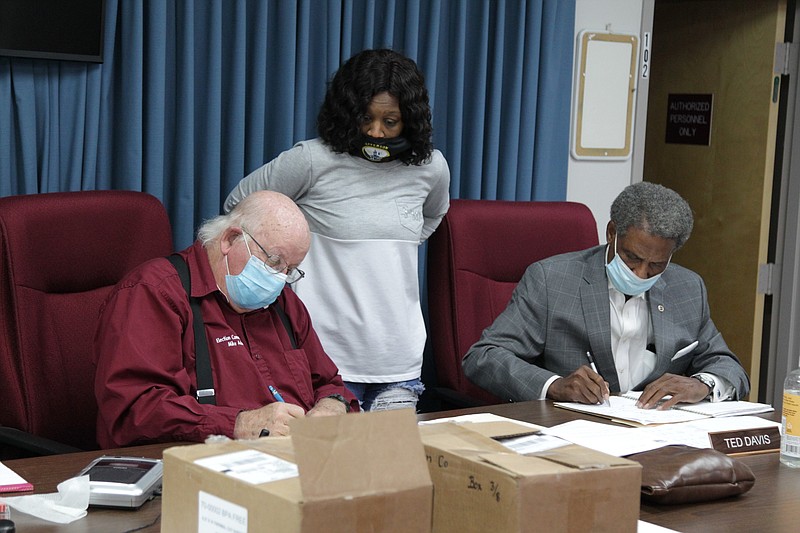 Tameka Reed (center) administrative assistant to the Jefferson County Election Commission, watches as commissioners Mike Adam, (left) and Ted Davis examine ballots Friday night as they prepare to certify the Nov. 3 election results in the county. 
(Pine Bluff Commercial/Dale Ellis)