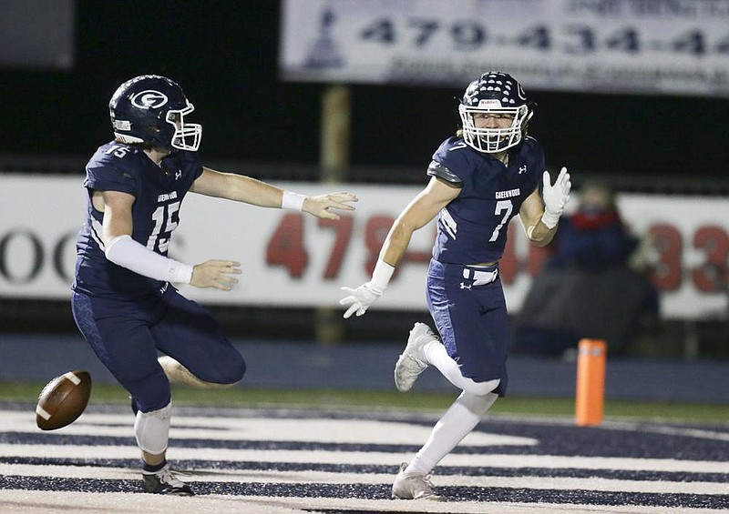 Greenwood’s Colin Daggett (7) celebrates with a teammate Friday after scoring a touchdown on a 25-yard interception return during the Bulldogs’ 55-7 victory over West Memphis at Smith-Robinson Stadium in Greenwood. The interception return was part of a 27-point second quarter for the Bulldogs.
(NWA Democrat-Gazette/Charlie Kaijo)

