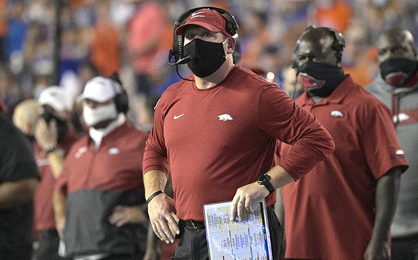 Arkansas acting head coach Barry Odom, center, watches a stadium video monitor after Florida scored a touchdown during the first half of an NCAA college football game, Saturday, Nov. 14, 2020, in Gainesville, Fla. (AP Photo/Phelan M. Ebenhack)