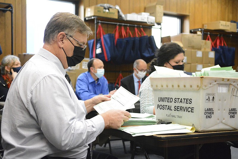 Election Bureau Director Albert L. Gricoski, left, opens provisional ballots alongside election bureau staff Christine Marmas, right, while poll watchers observe from behind at the Schuylkill County Election Bureau in Pottsville, Pa. on Tuesday, Nov. 10, 2020.
