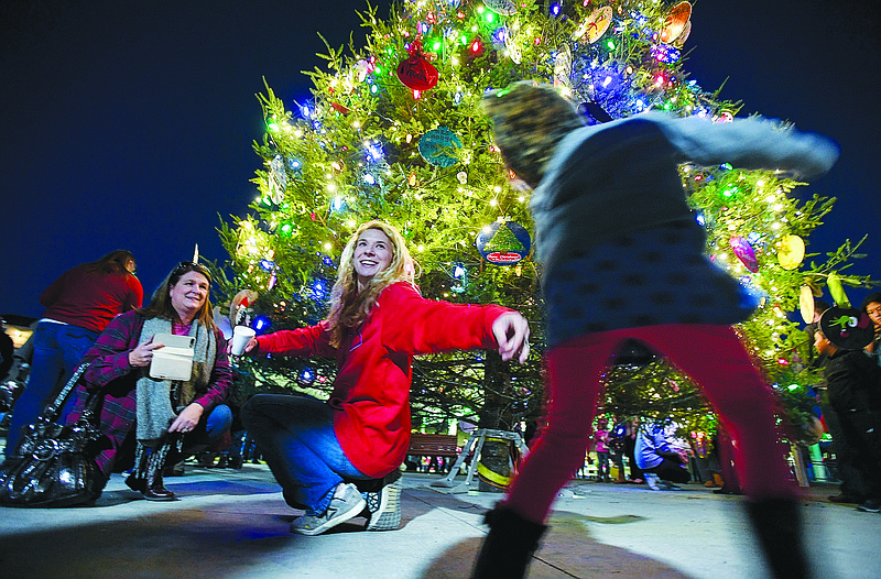 NWA Democrat-Gazette/CHARLIE KAIJO Amanda Ward of Fayetteville reaches for Leighann Ward, 3 in front of a large lit Christmas tree during the 2nd annual Christmas on The Creek on Saturday, November 25, 2017 at Shiloh Square in Springdale. Springdale celebrated it’s 2nd annual holiday tradition, "Christmas on the Creek", which included photos with Santa, mini train rides,  the lighting of the region's largest live community Christmas tree and a parade
