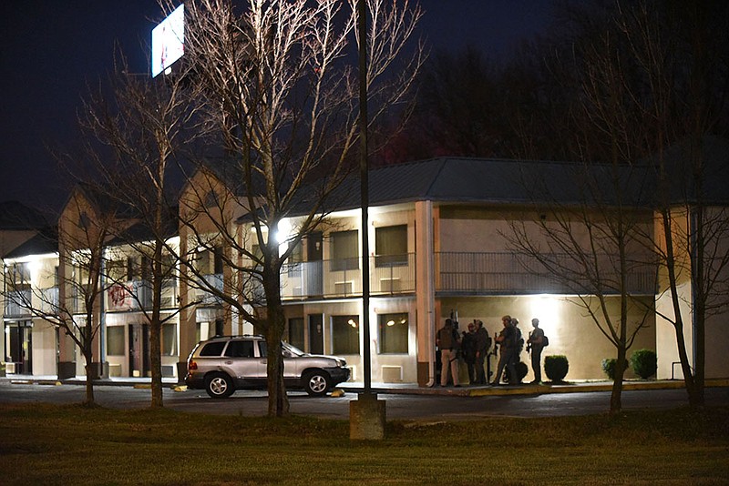 Officers stand Tuesday Nov. 17 2020 night outside the Econo Lodge at Interstate 49 and Walton Boulevard.
(NWA Democrat-Gazette/Flip Putthoff)