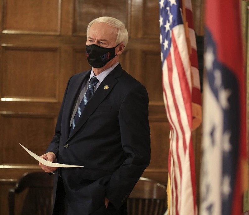 Governor Asa Hutchinson listens to the report from Health Secretary Dr. Jose Romero on Tuesday, Nov. 17 in Little Rock during the weekly COVID-19 press conference at the state Capitol. (Arkansas Democrat-Gazette/Staton Breidenthal)