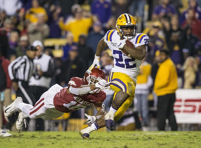 NWA Democrat-Gazette/BEN GOFF @NWABENGOFF
Clyde Edwards-Helaire, LSU running back, breaks the tackle of Myles Mason, Arkansas strong safety, on his way to a touchdown in the third quarter Saturday, Nov. 23, 2019, at Tiger Stadium in Baton Rouge, La. 