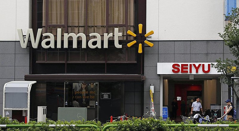 Walmart and Seiyu signs are seen in Tokyo in this file photo. Walmart is selling off 85% of the Japa- nese supermarket subsidiary in a deal valued at $1.16 billion. (AP) 